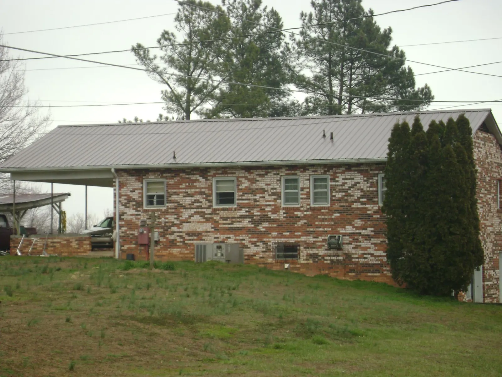 Gray metal roof on a brick split level home with a carport in Bay City